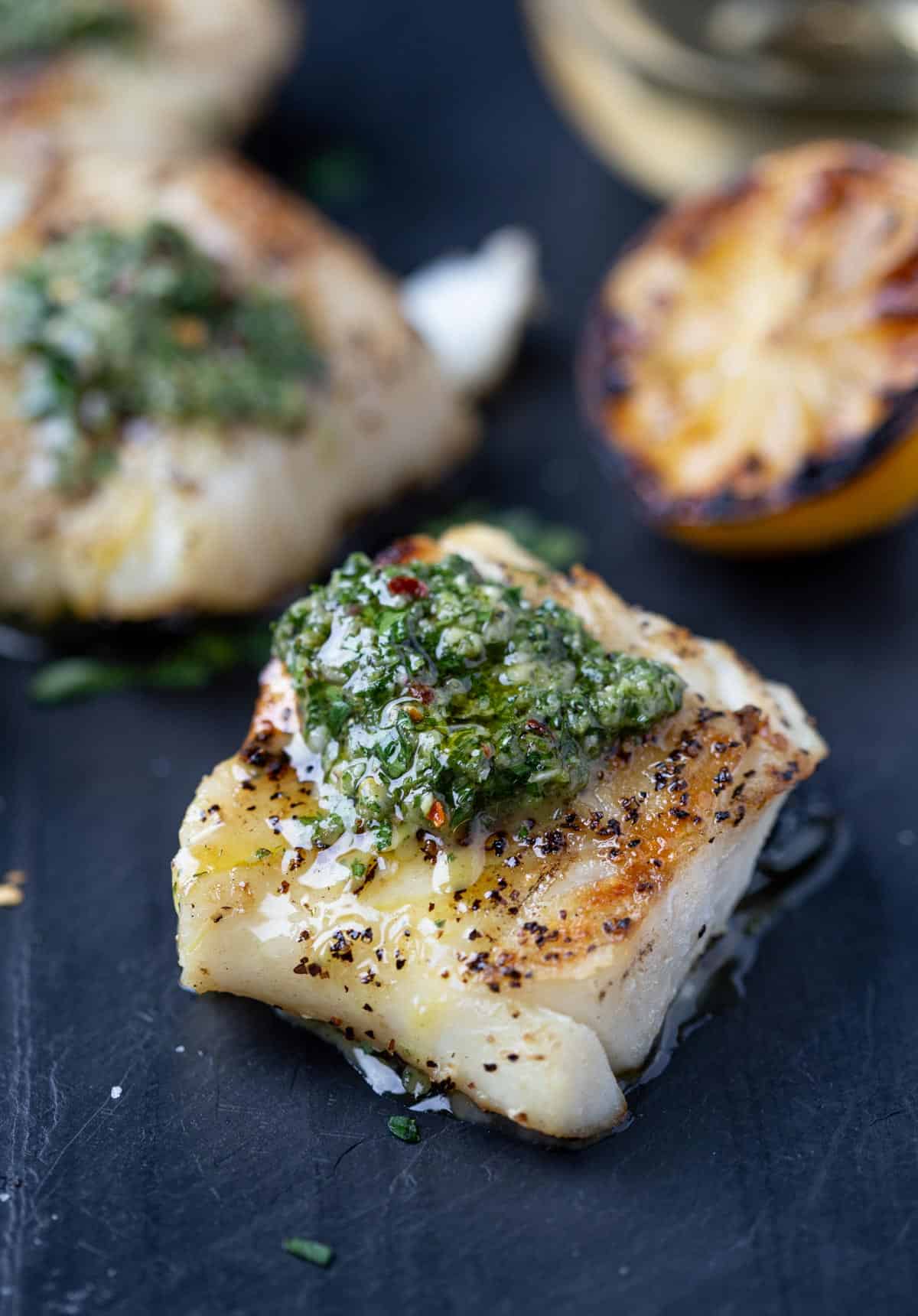 Grilled Cod topped with chimichurri sauce on a platter