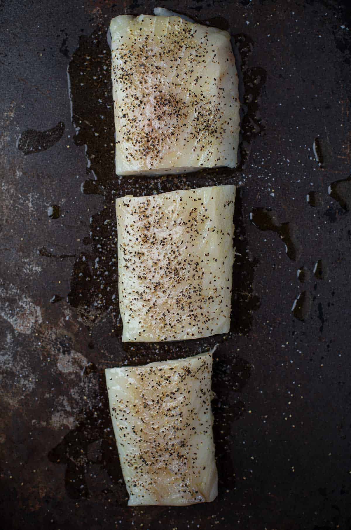 raw cod steaks on a baking dish