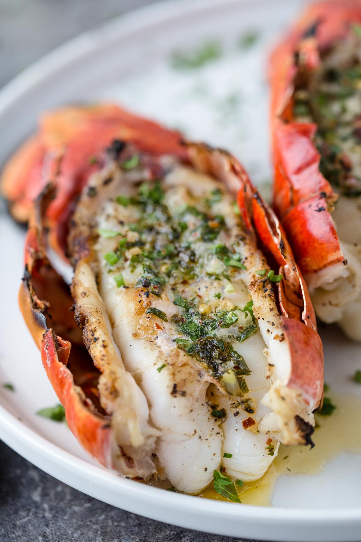 A Grilled Lobster Tail with Herb Compound Butter and a glass of wine for wine pairing
