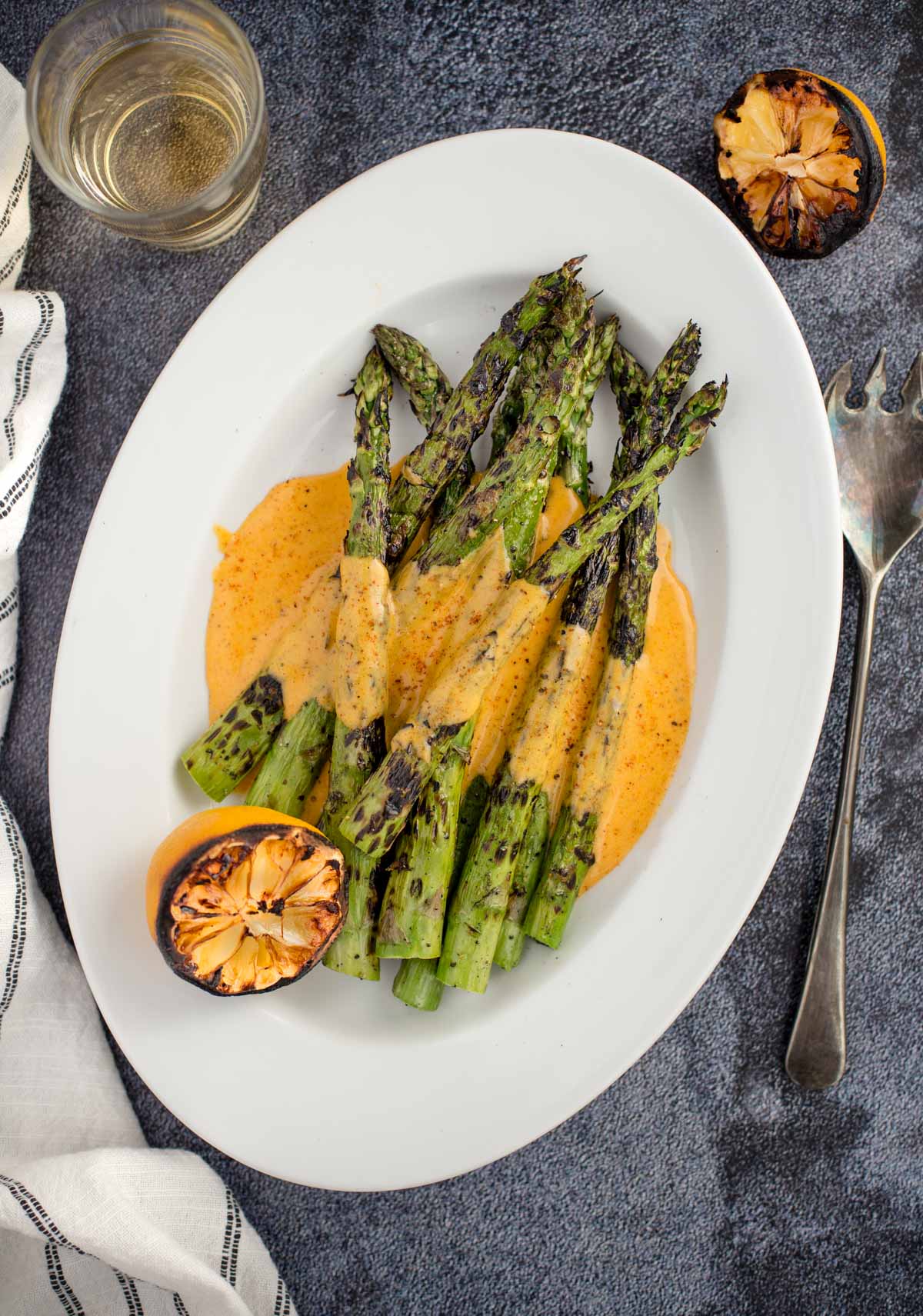 Grilled Asparagus with a BBQ flavored Hollandaise sauce on a white plate