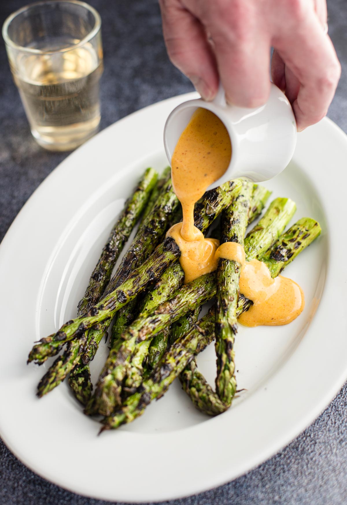Drizzling a BBQ inspired Hollandaise Sauce over asparagus