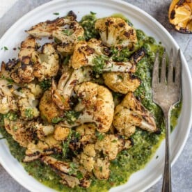 Grilled Cauliflower with a Cilantro Pistou on a white platter