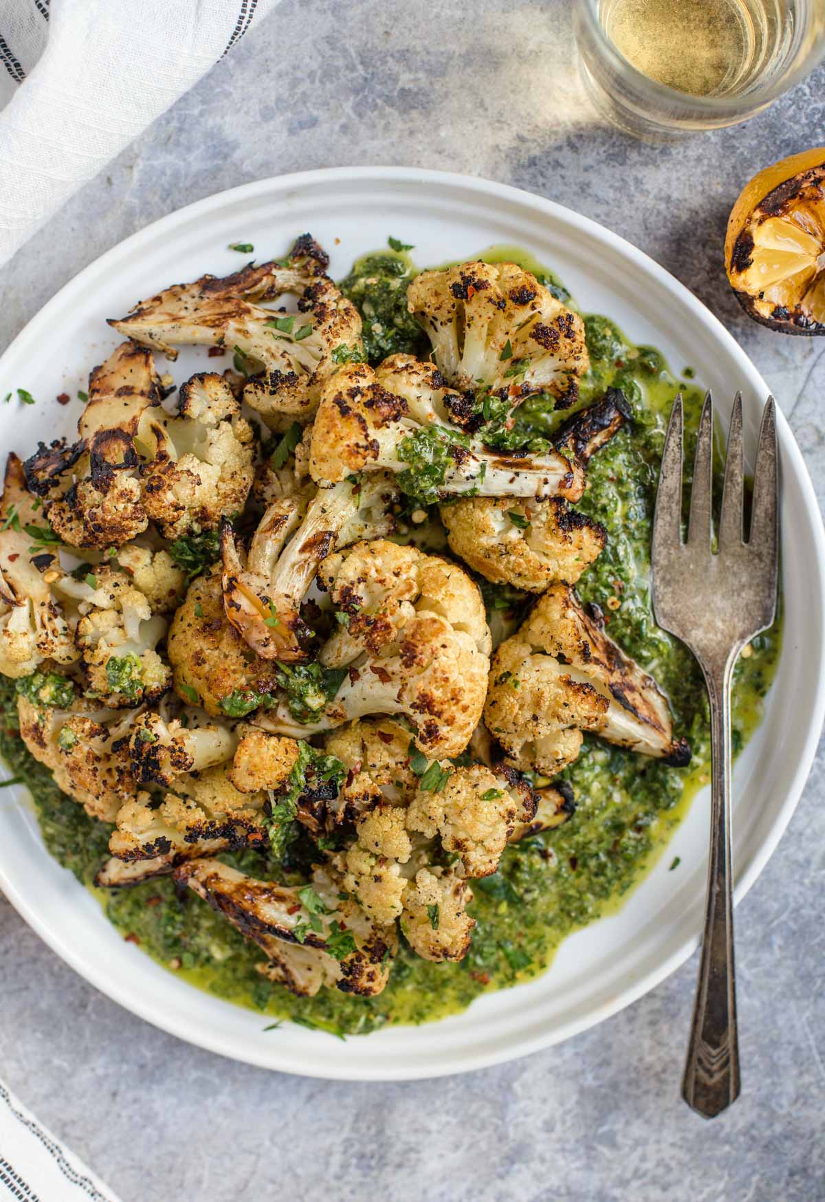 Grilled Cauliflower on a platter with a cilantro Pistou (similar to a French Pesto)