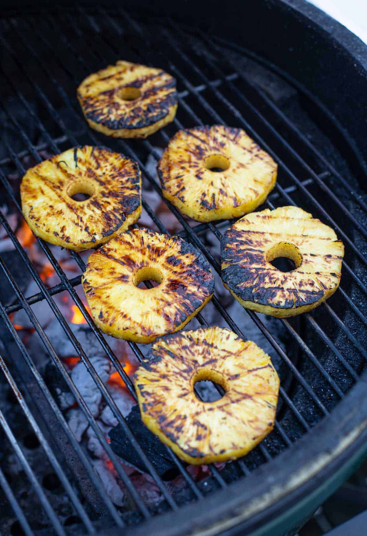Grilled Pineapple slices over direct heat on the grill.