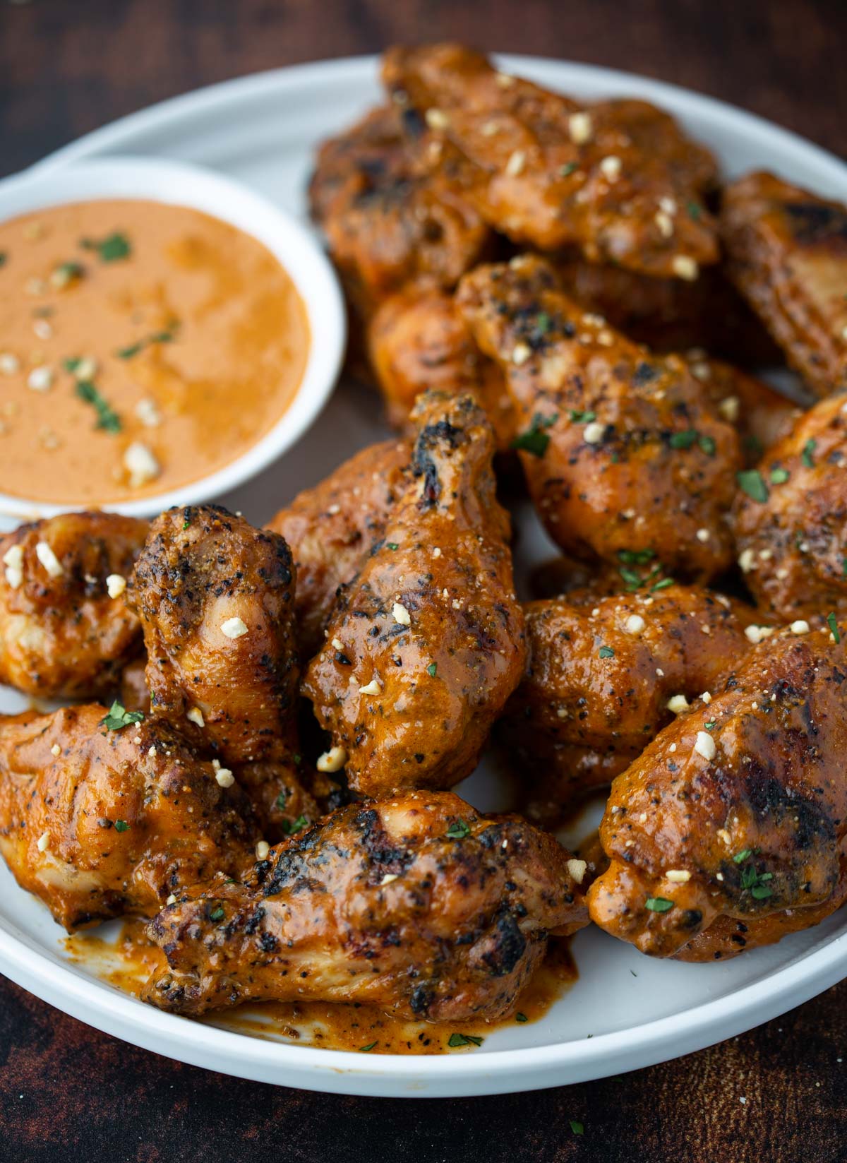 Grilled Chicken Wings with Spicy Peanut Sauce on a platter with some dipping sauce