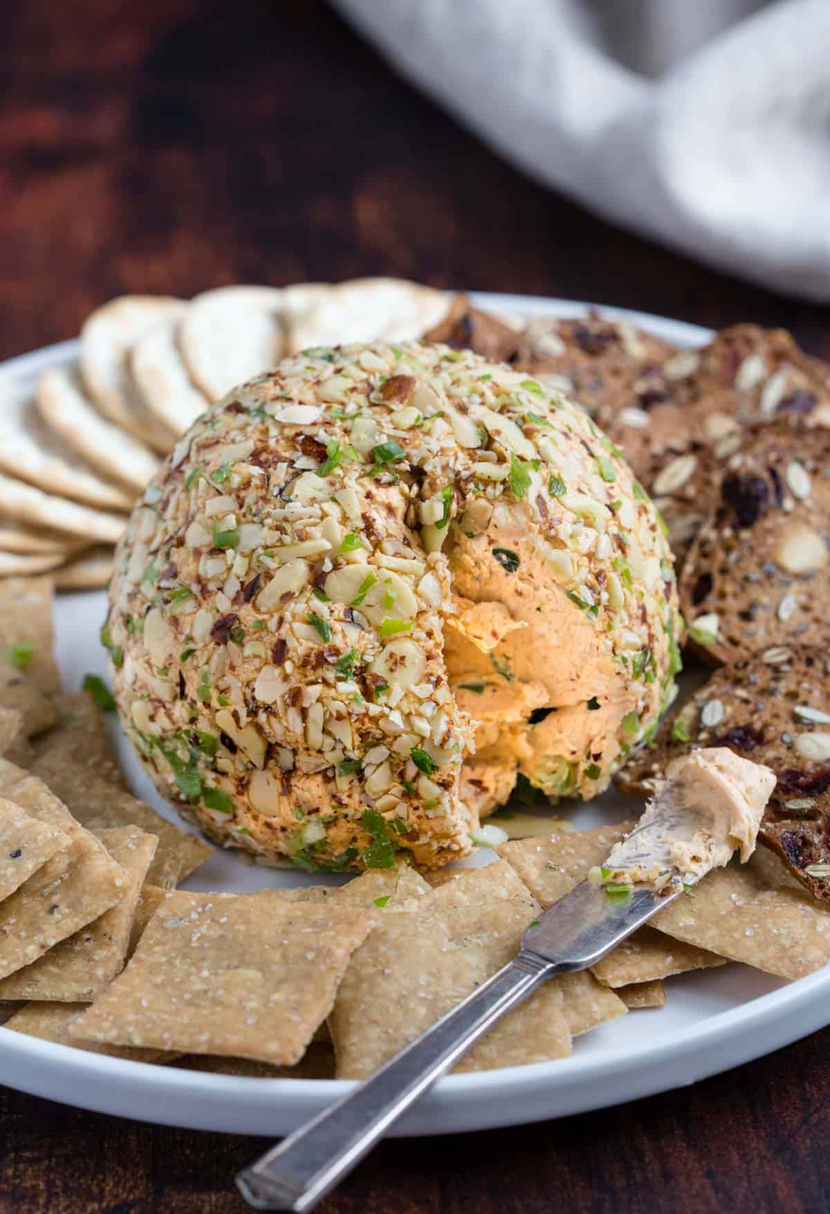 A smoked cheese ball on a platter with crackers