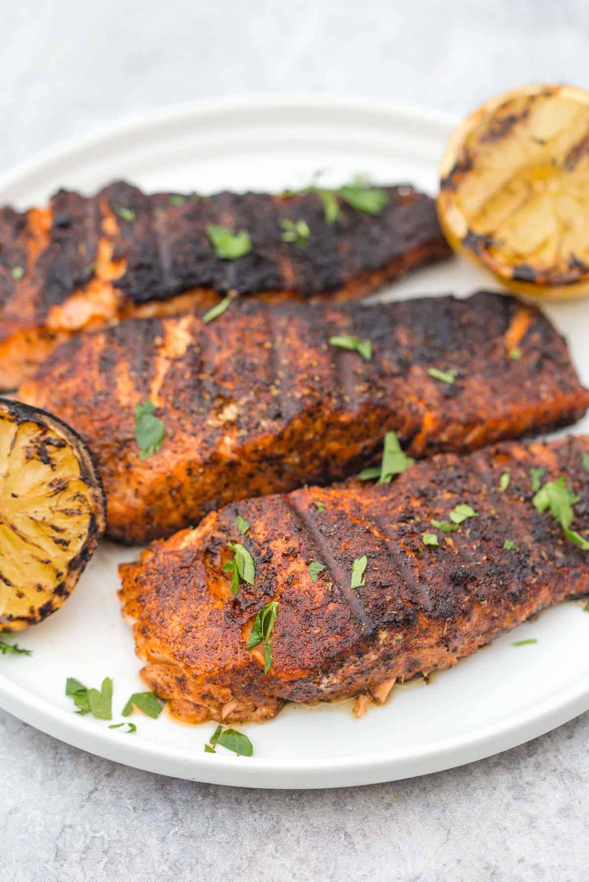 Blackened salmon fillets on a plate.