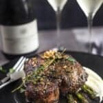 Grilled pork chops with wine brown butter sauce over asparagus and served with Prosecco Superiore Wine.
