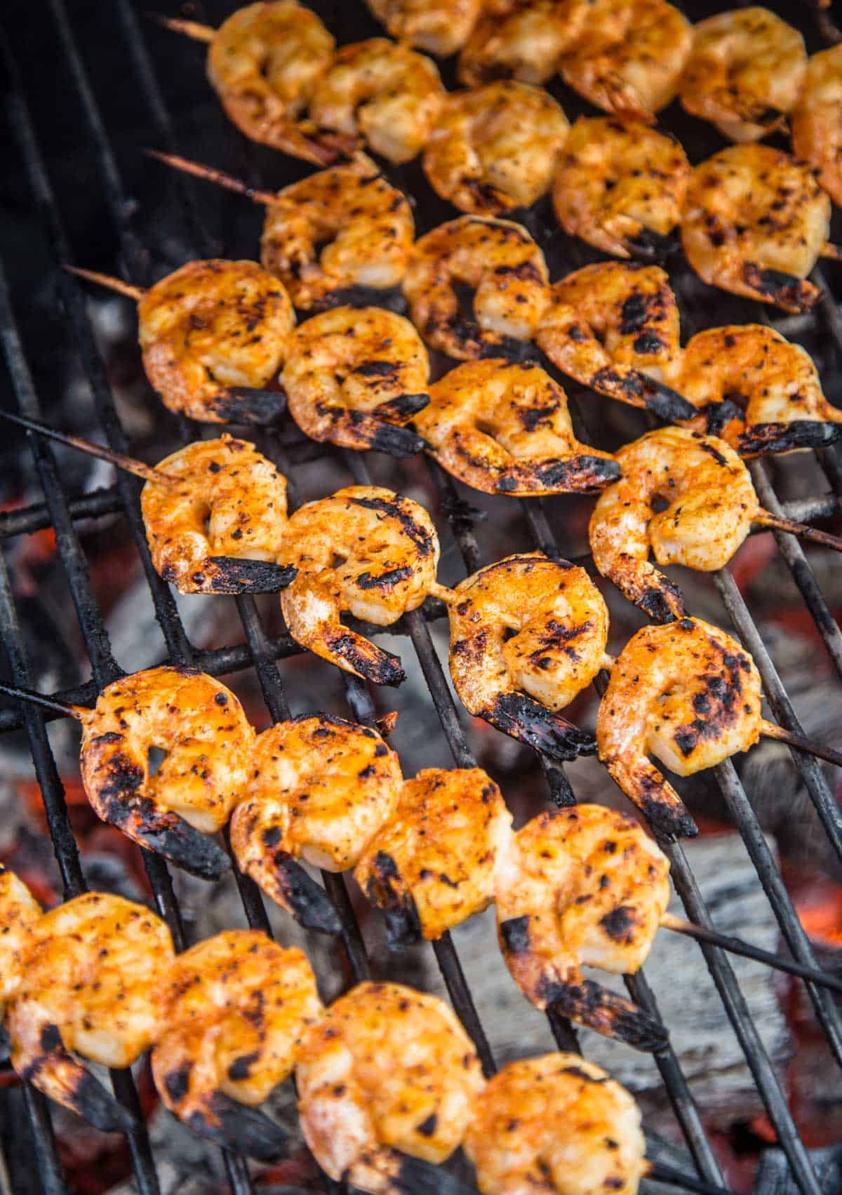 Skewers of shrimp cooking on the grill.