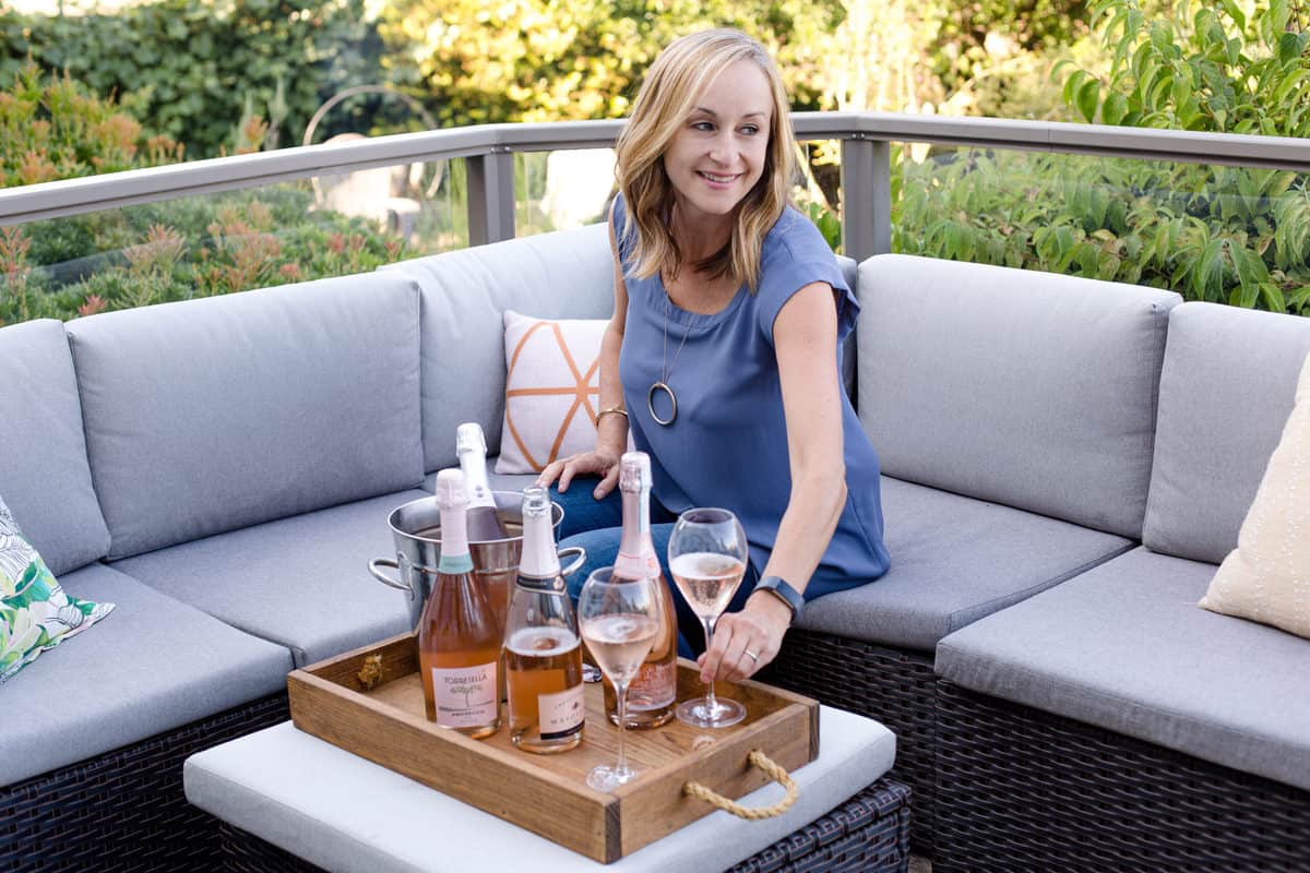 Mary Cressler on a couch with prosecco.