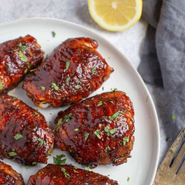 Grilled and glazed chicken thighs on a serving platter.
