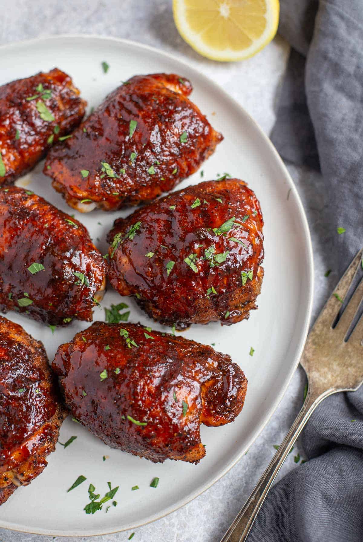 Pellet grilled chicken thighs on a white platter