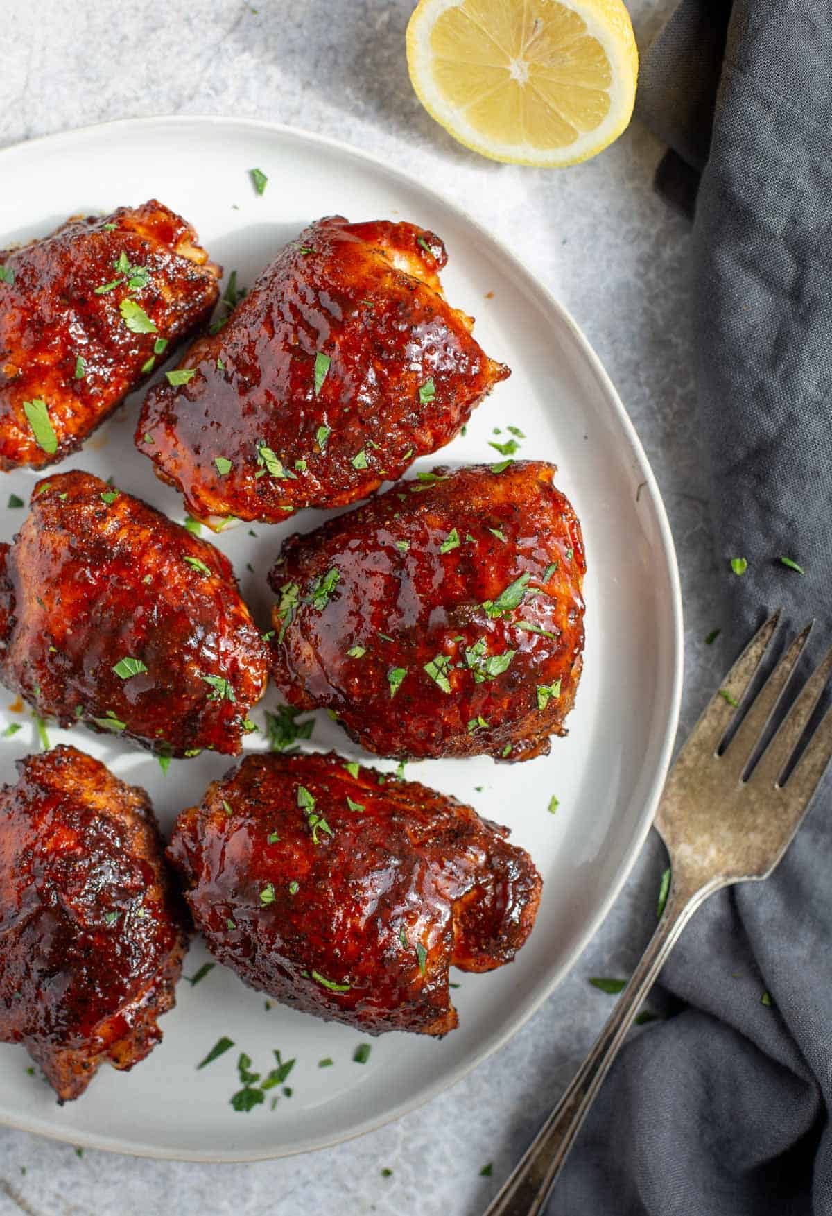 Pellet grilled chicken thighs, glazed, and on a plate.