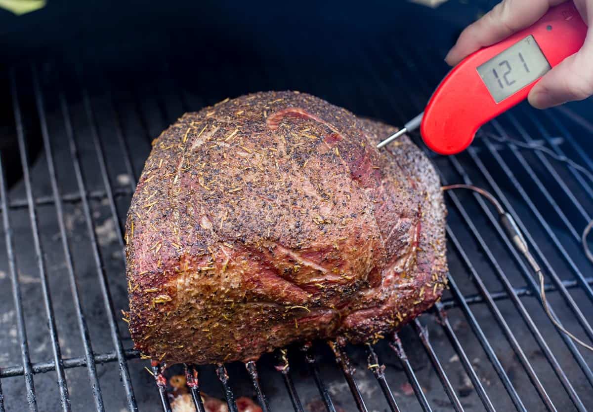 Taking temperature of a large roast using a Thermapen One digital thermometer.