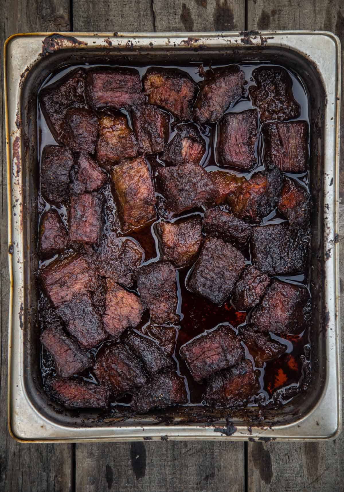 Brisket burnt ends in a metal hotel pan.