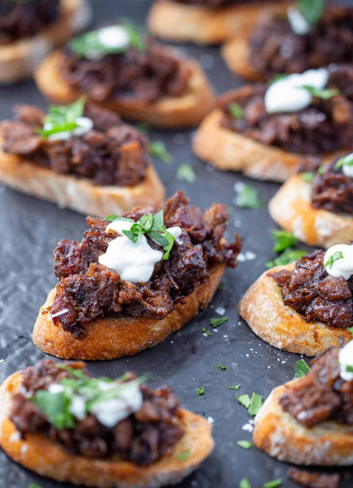 Brisket bruschetta crostini on a serving platter.