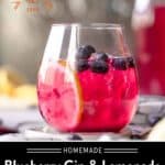 Wine glass of blueberry gin & lemonade cocktail with lemon and blueberry garnish