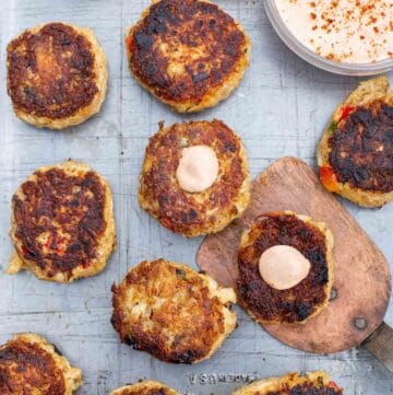 Grilled Salmon and Crab Cakes with dipping sauce on a platter.