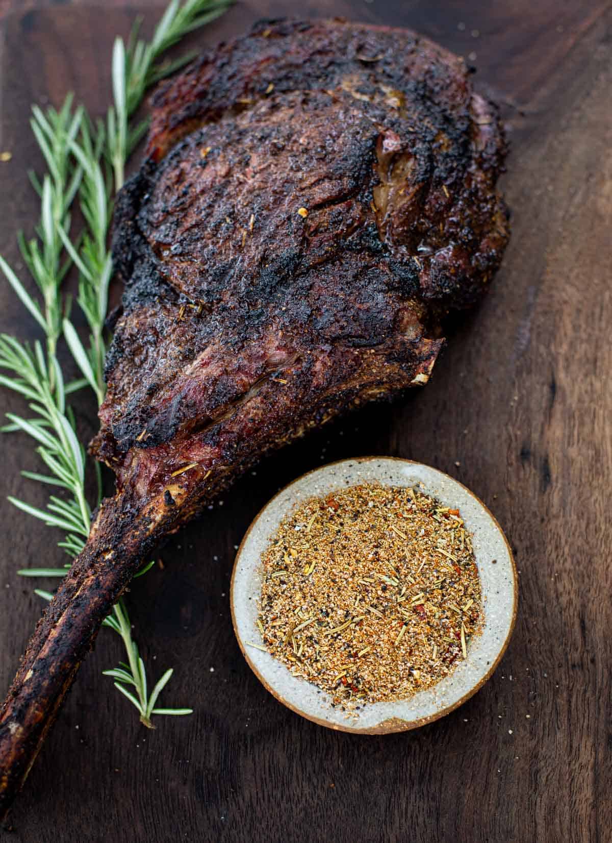 Grilled Tomahawk steak with Vindulge Beef Seasoning on a cutting board.