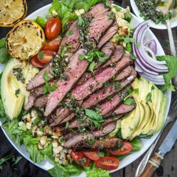 Grilled Flank Steak Salad with Chimichurri sauce in a bowl.