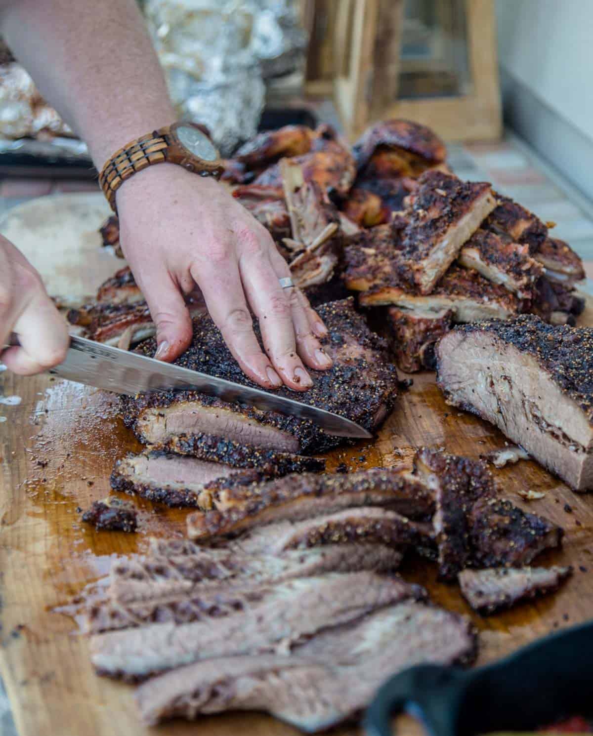 Slicing a smoked brisket on a cutting board