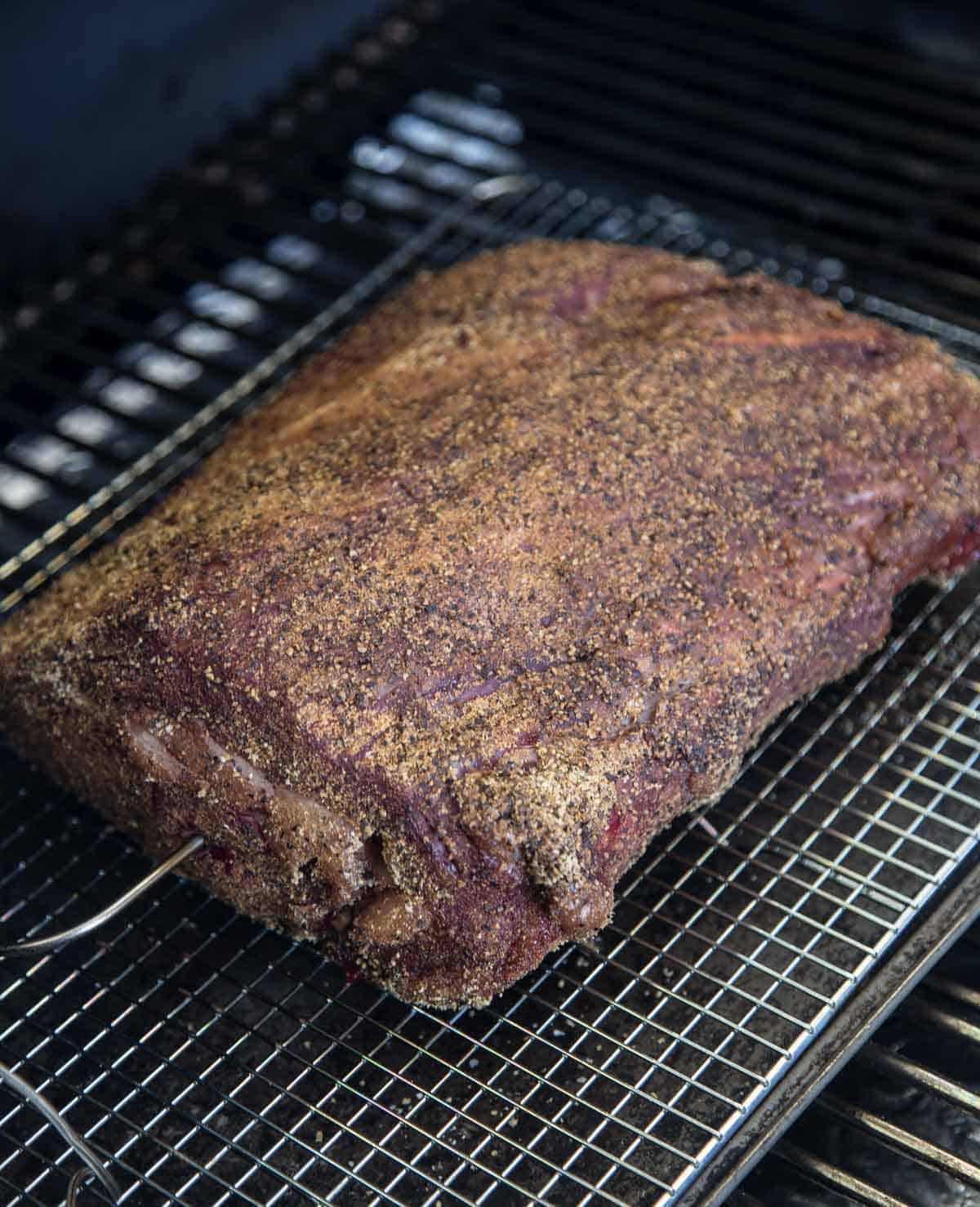 A boneless prime rib cooking on a smoker