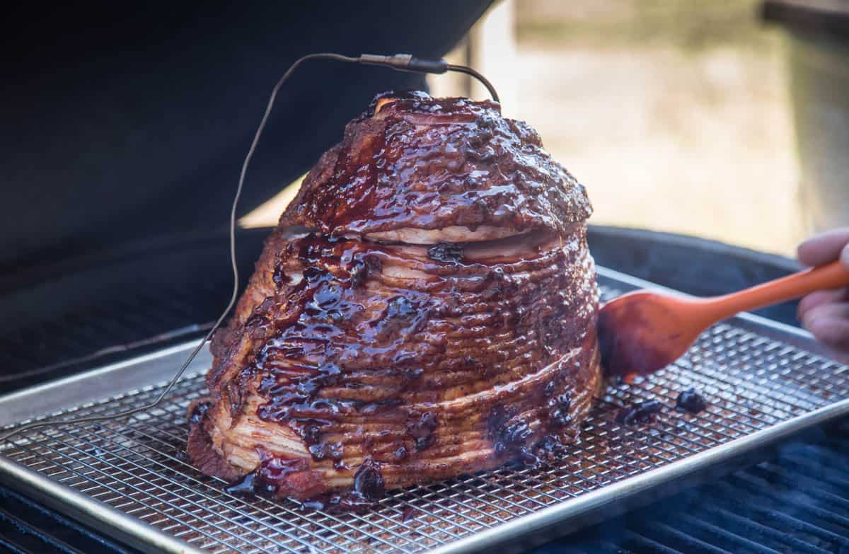 Glazing a double smoked ham with a cherry bourbon sauce