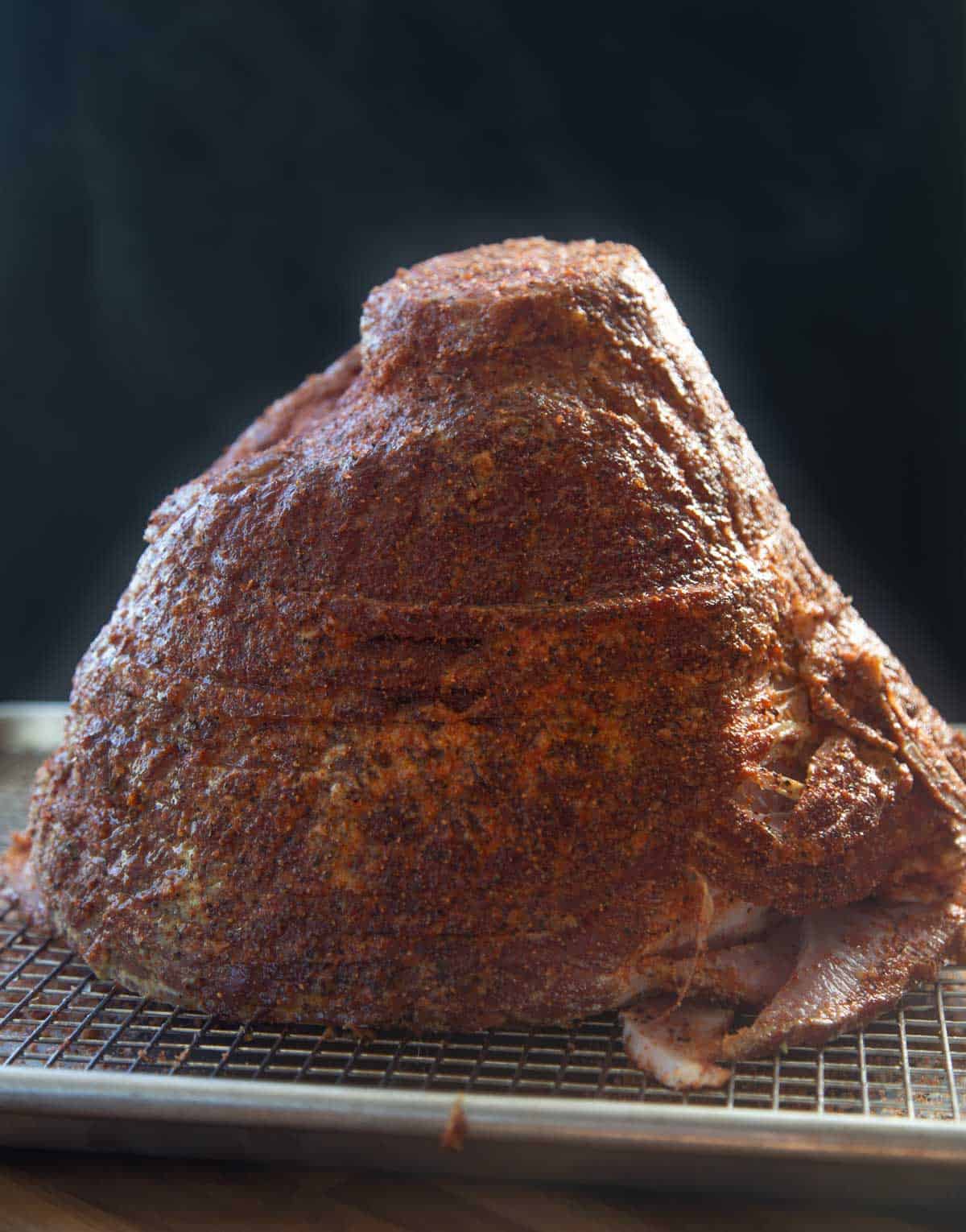 seasoned ham on a sheet tray ready to go into the smoker.