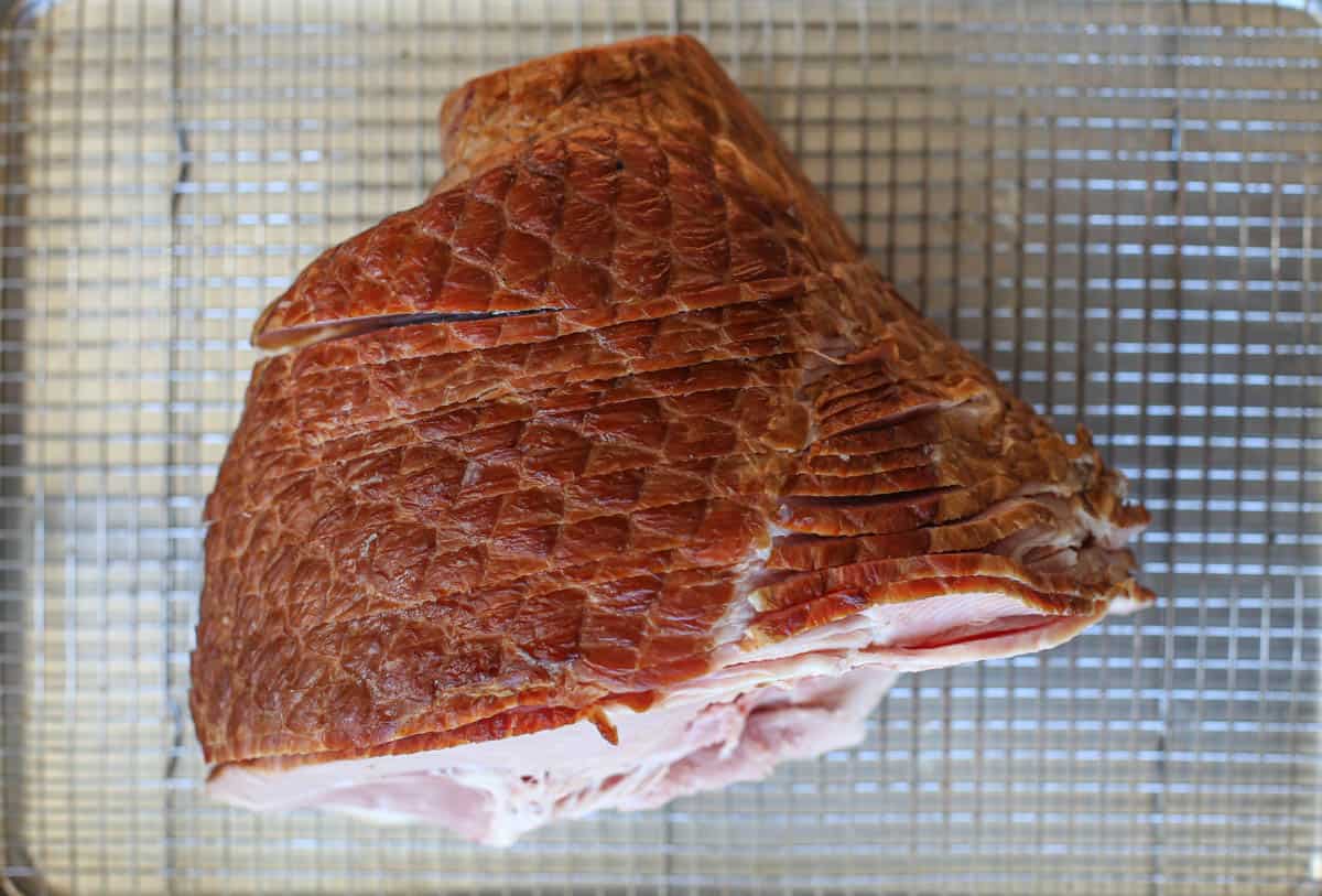 An uncooked ham on a sheet tray