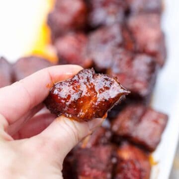 A cube of pork belly burnt ends with sauce.