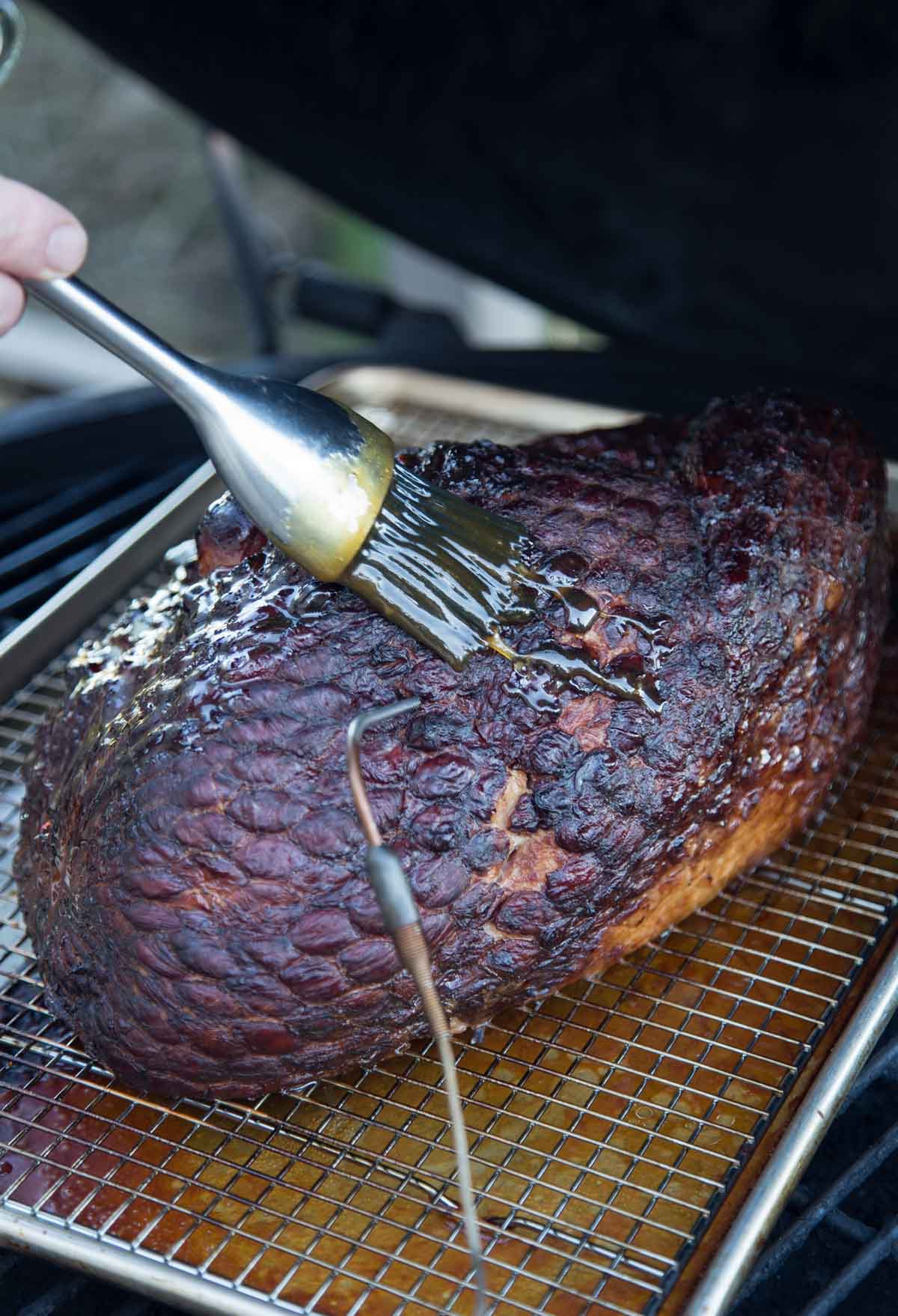 Glazing a smoked ham on a smoker