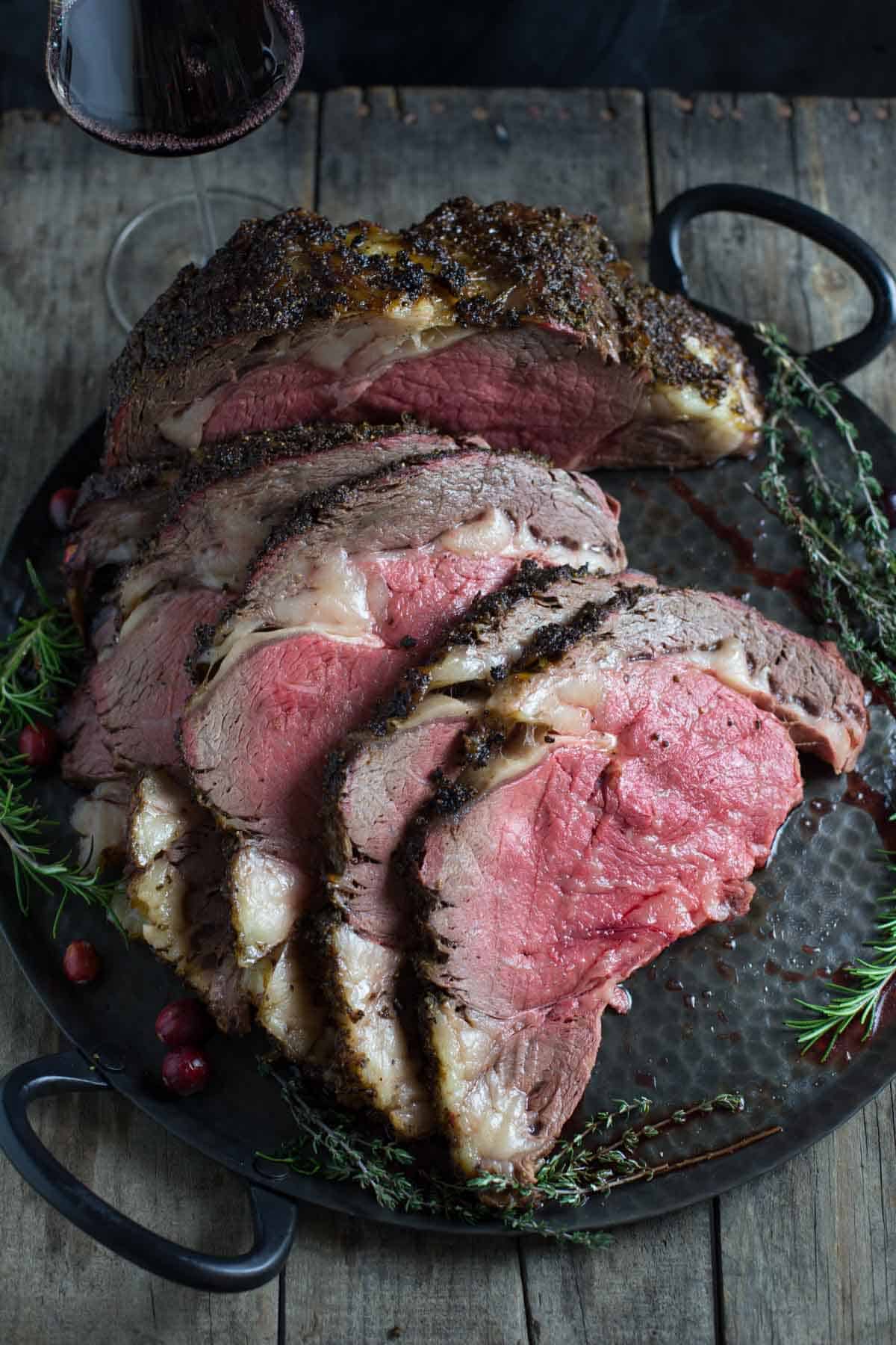 Slices of rare smoked prime rib on a platter.