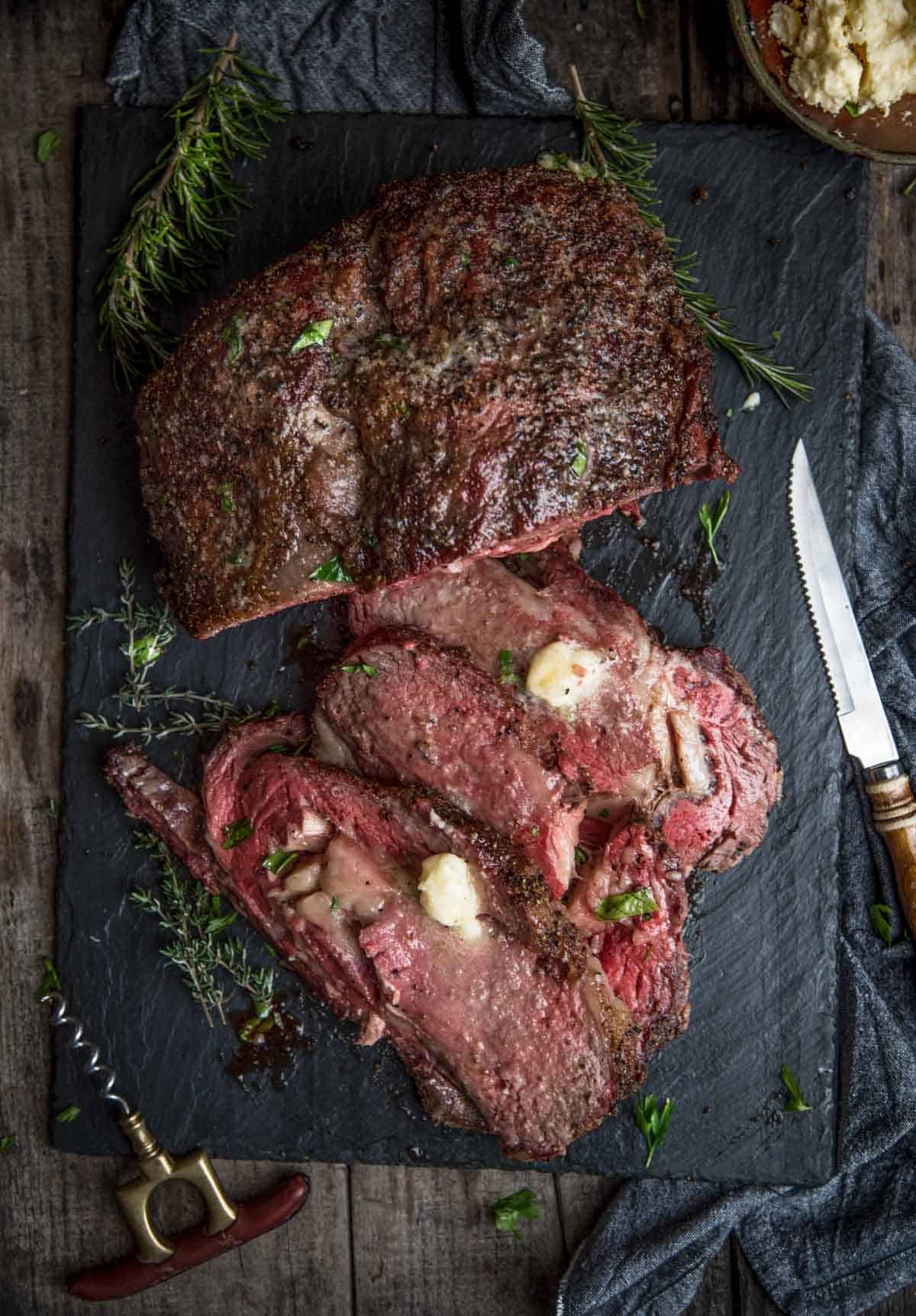 Smoked Prime Rib with horseradish butter on a serving platter