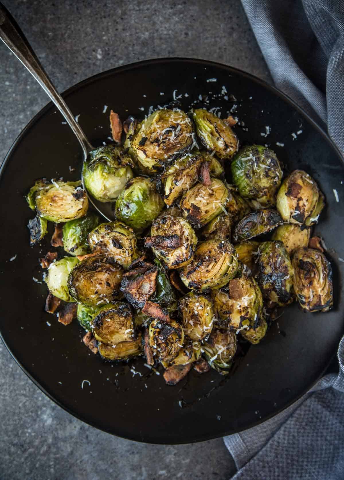 Grilled Brussels Sprouts with bacon and balsamic in a serving dish