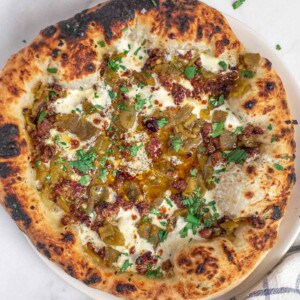 Grilled Green Chile Pizza on a wooden board.