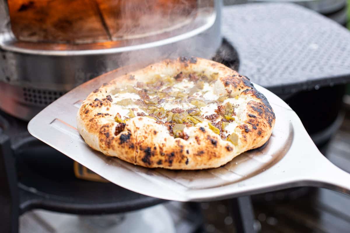 Removing green chile pizza from solo stove pi pizza oven.