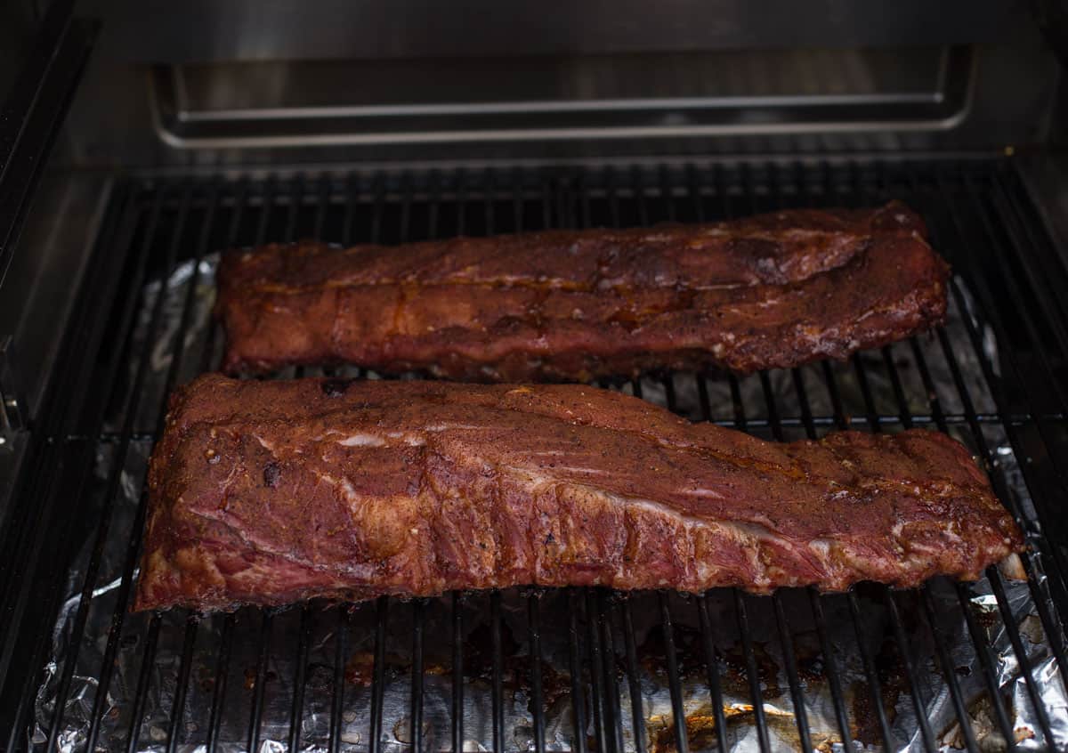 two racks of ribs on the smoker