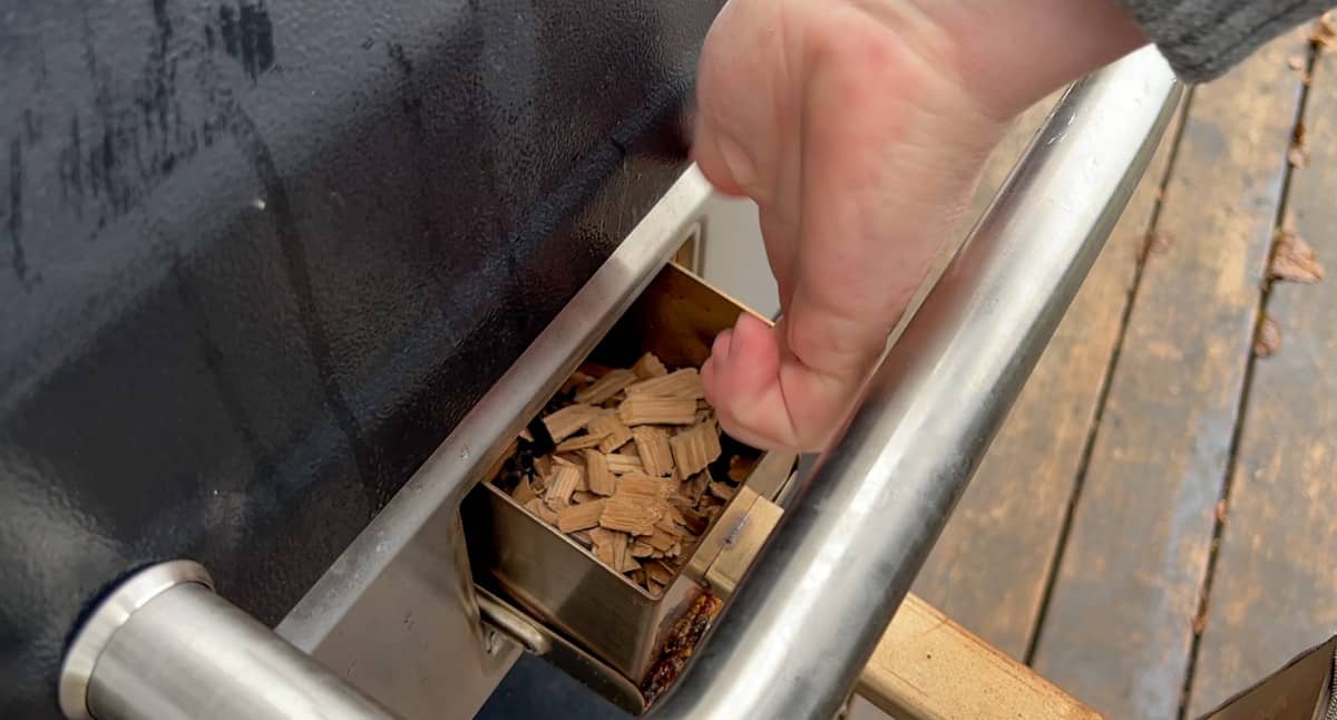 Putting wood chips into the Camp Chef Woodwind Pro Smoke Box