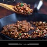 Skillet of Mexican cauliflower chorizo sausage with a large wooden spoonful in the foreground