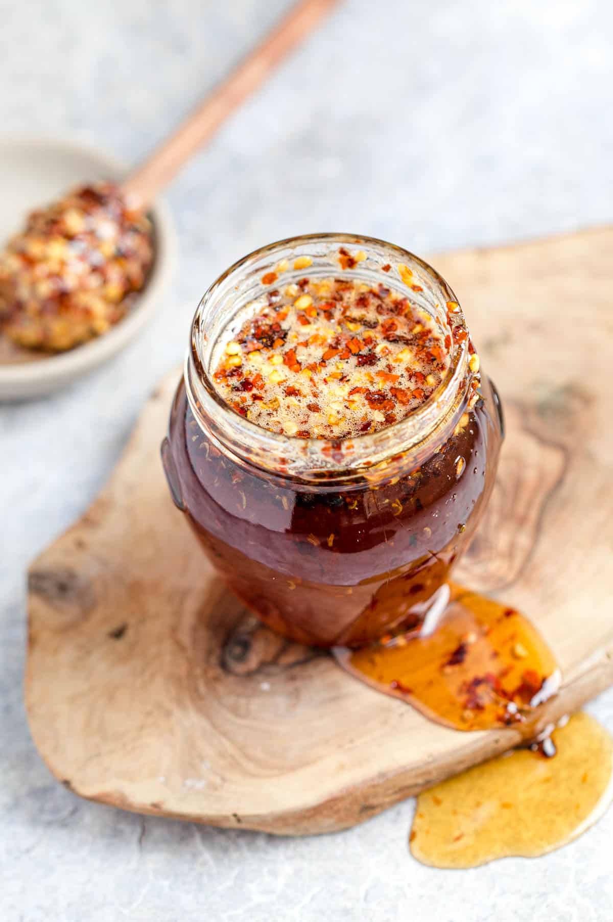A jar of easy hot honey with a honey stick 