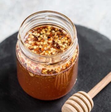 Savory Hot Honey in a mason jar with honey stick.