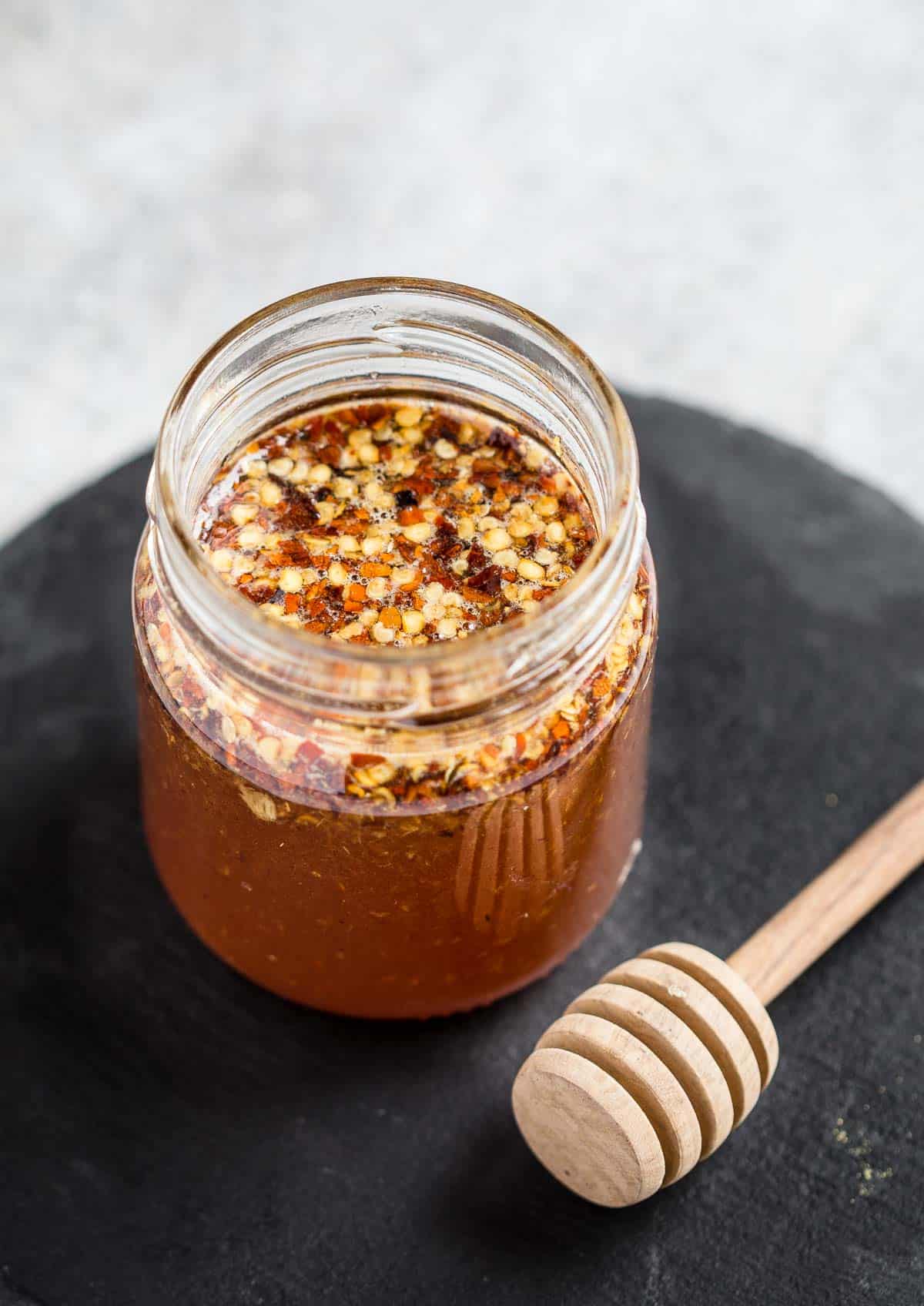 Savory Hot Honey in a mason jar with honey stick.