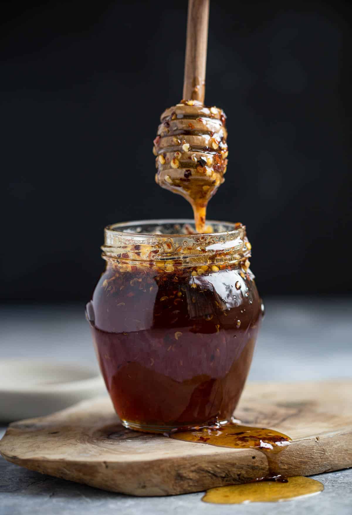 Hot Honey in a jar with a honey stick drizzling on top