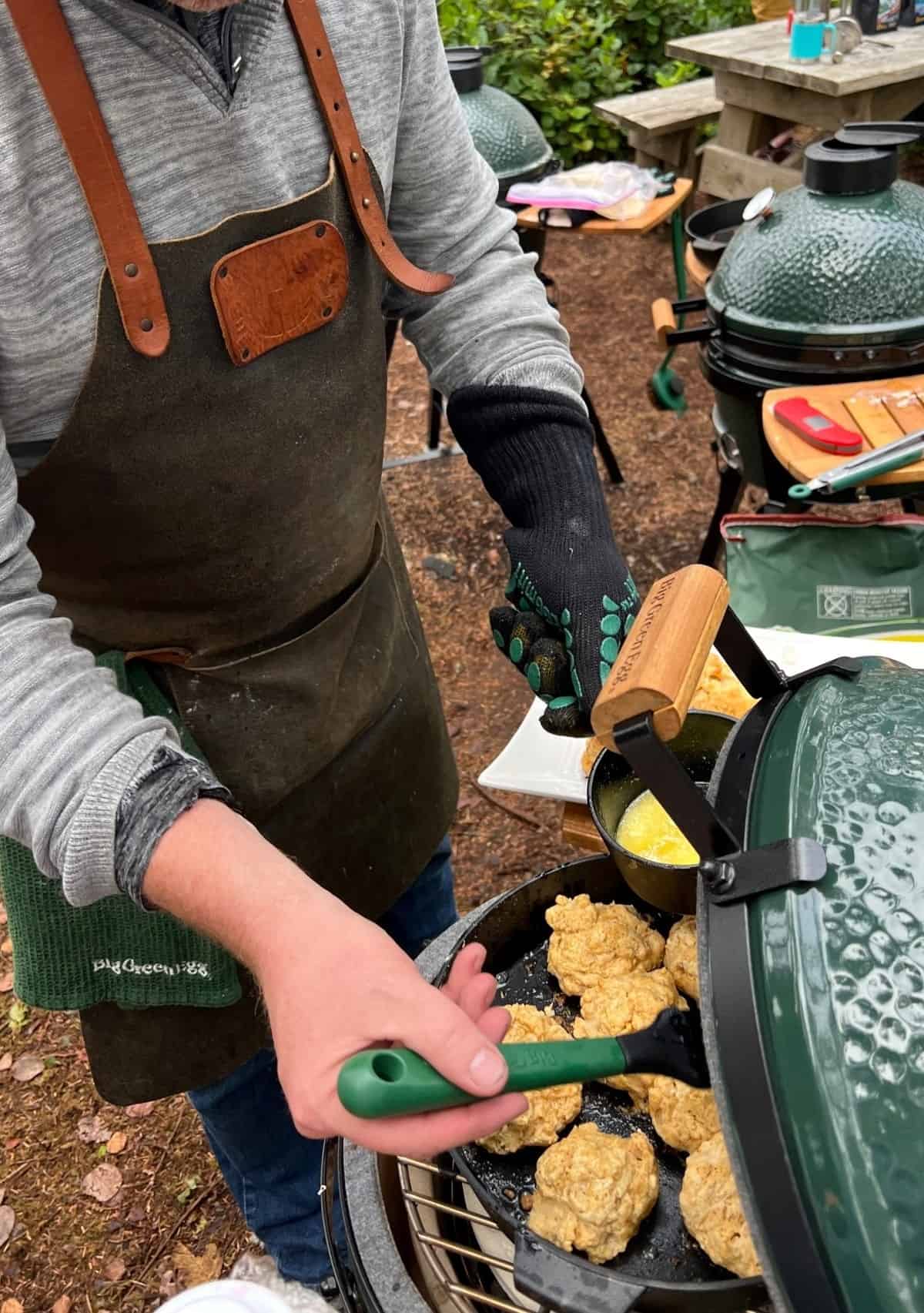 Sean Martin of Vindulge glazing drop biscuits on Big Green Egg with melted butter.