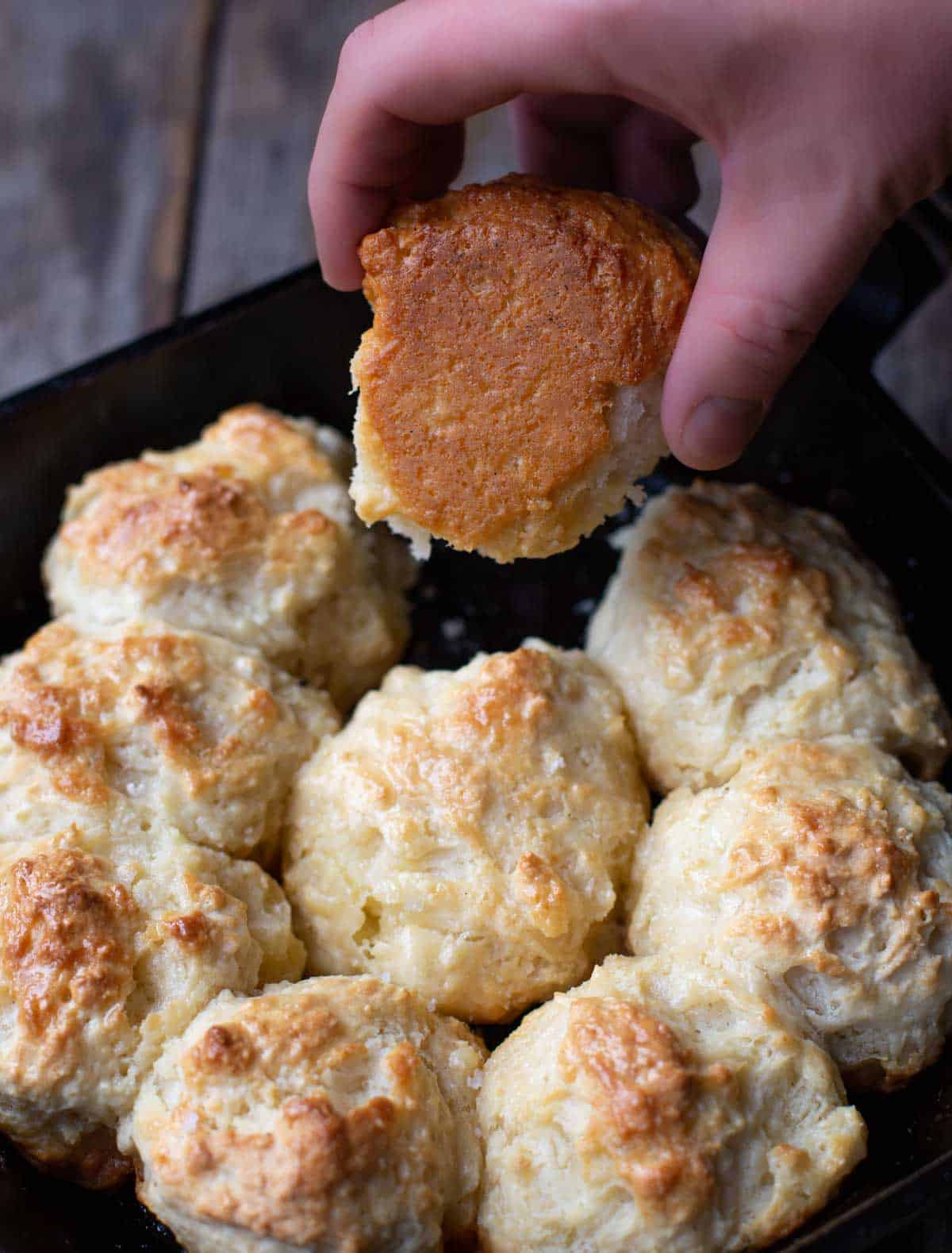 The underside of cast iron drop biscuits showing the golden crust.
