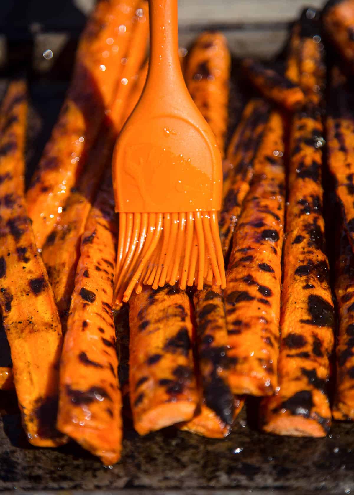 Drizzling grilled carrots with a sweet glaze