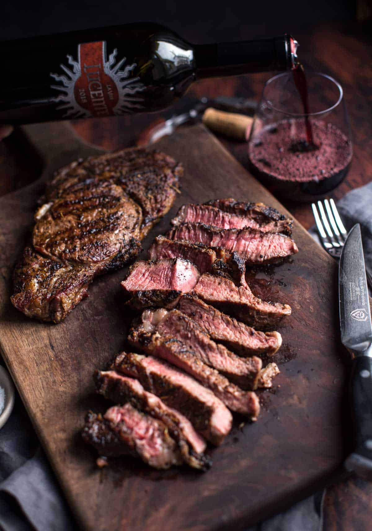 Ribeye steak sliced with a glass of red wine.