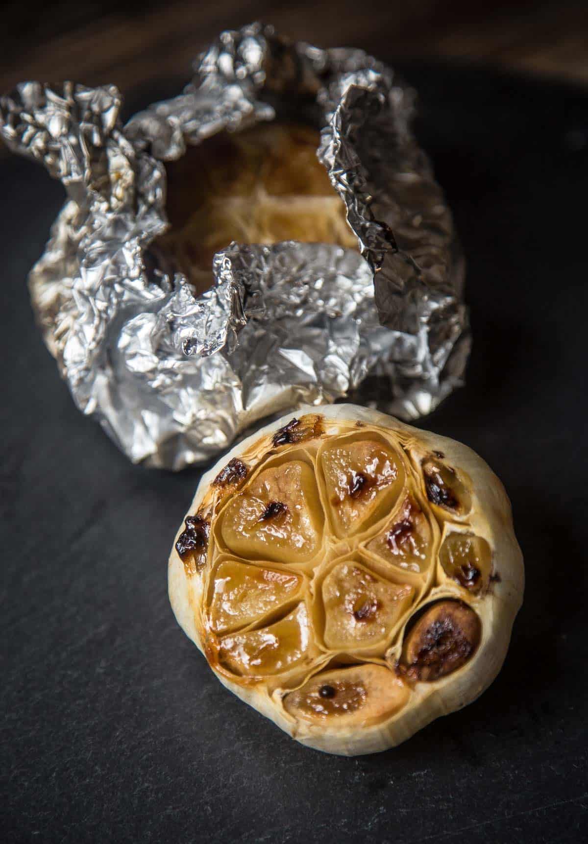A roasted garlic bulb on a serving platter