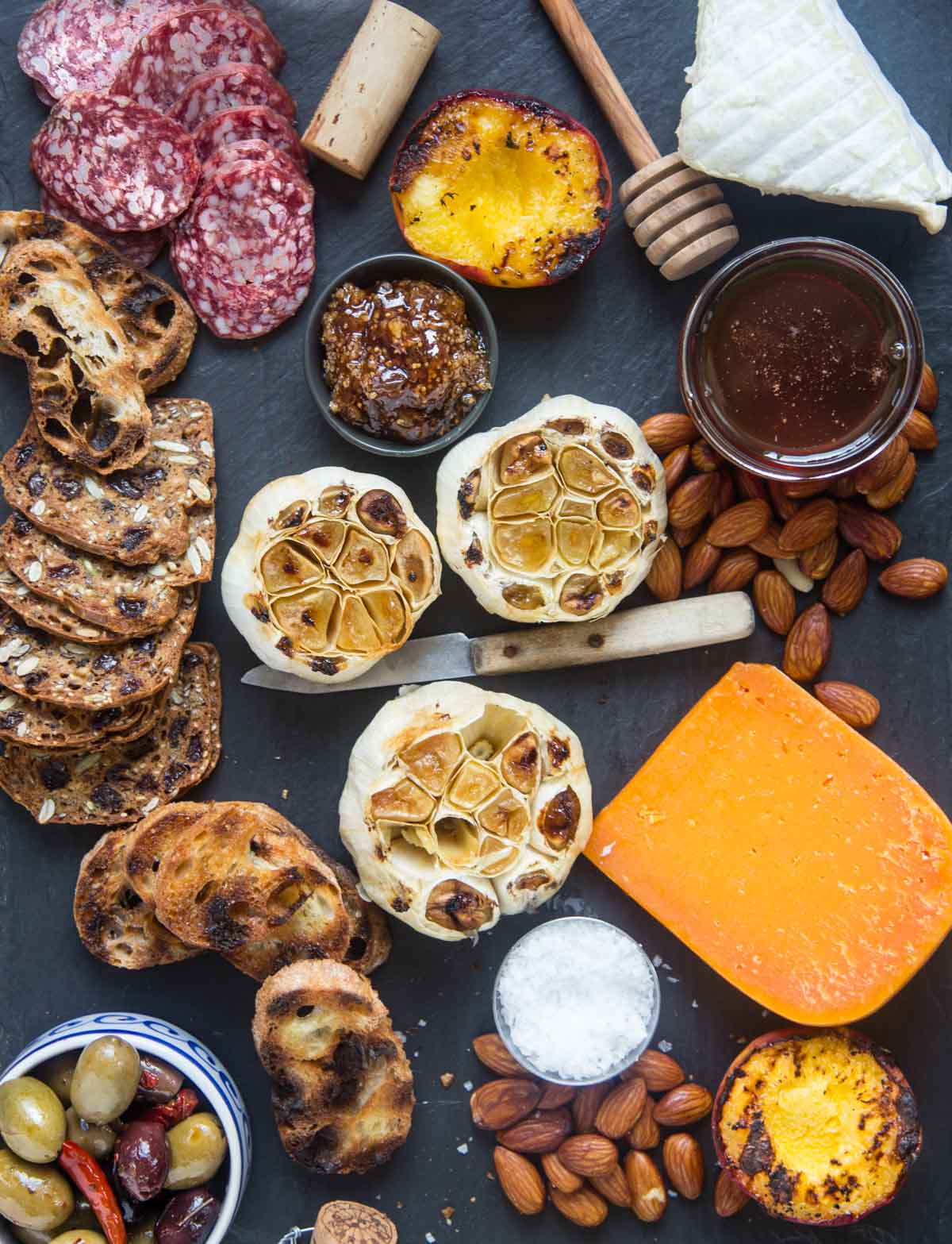 A spread with roasted garlic on the grill with crackers, cheese, and dips