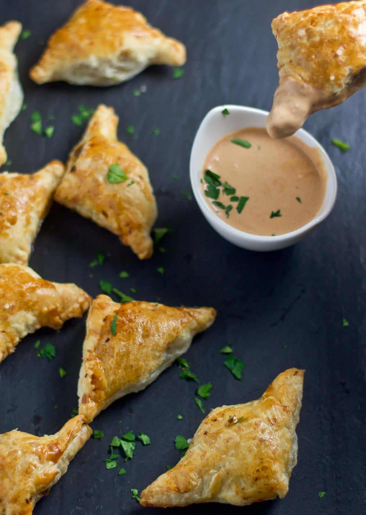 Dipping beef empanadas into a creamy bbq dipping sauce